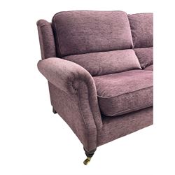 Parker Knoll - pair of large two-seat sofas upholstered in purple fabric, turned mahogany finish front feet with brass cups and castors 