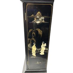 20th century 8-day chain driven black lacquered longcase clock - with a swans neck pediment and break-arch hood door, fully glazed trunk door displaying brass cased weights and pendulum, case sides, hood and plinth profusely decorated in gold relief and chinoiserie figures, brass break arch dial with an etched centre and silvered chapter ring, German two train movement striking the hours and half hours on two gong rods. With weights and pendulum.
