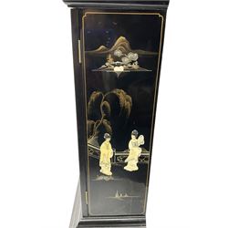 20th century 8-day chain driven black lacquered longcase clock - with a swans neck pediment and break-arch hood door, fully glazed trunk door displaying brass cased weights and pendulum, case sides, hood and plinth profusely decorated in gold relief and chinoiserie figures, brass break arch dial with an etched centre and silvered chapter ring, German two train movement striking the hours and half hours on two gong rods. With weights and pendulum.

