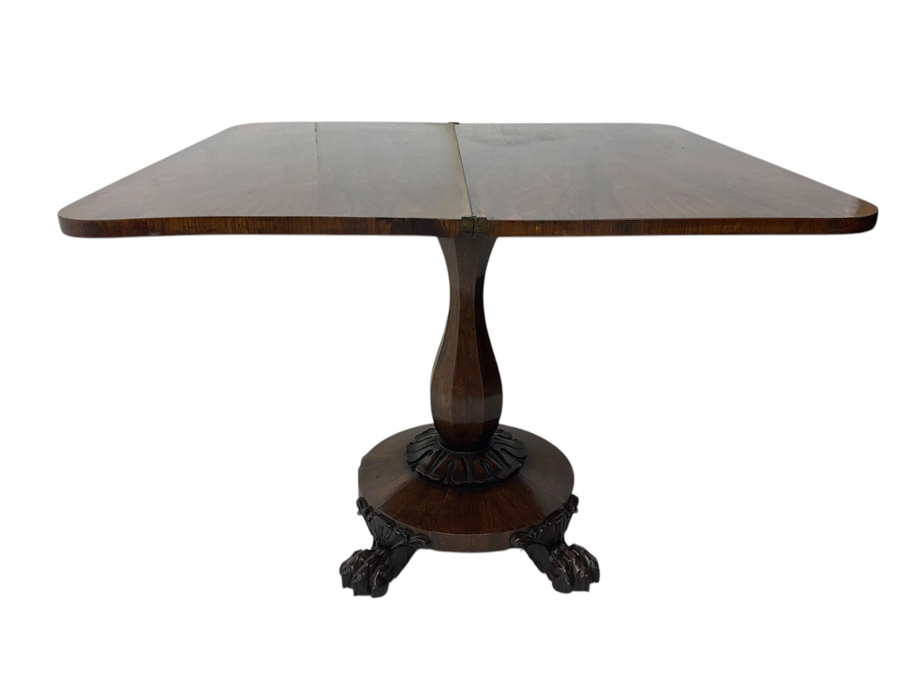 Victorian mahogany tea table, rectangular top with rounded corners, folding and swivelling to reveal interior surface, supported on a faceted baluster-shaped column, raised on a circular platform base with carved acanthus details, ending in four lion paw feet