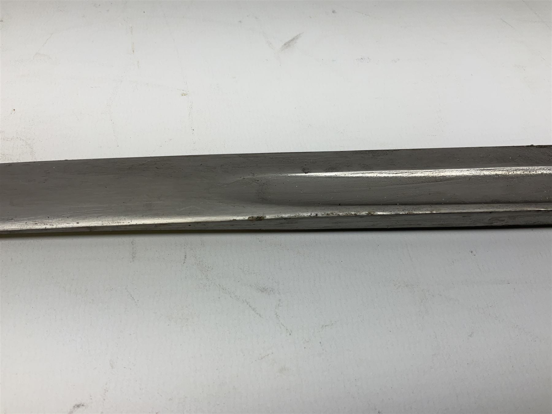 Turkish Model 1874 sword bayonet with 57.5cm curving steel fullered blade and chequered black grip, in steel mounted leather scabbard L75.5cm overall