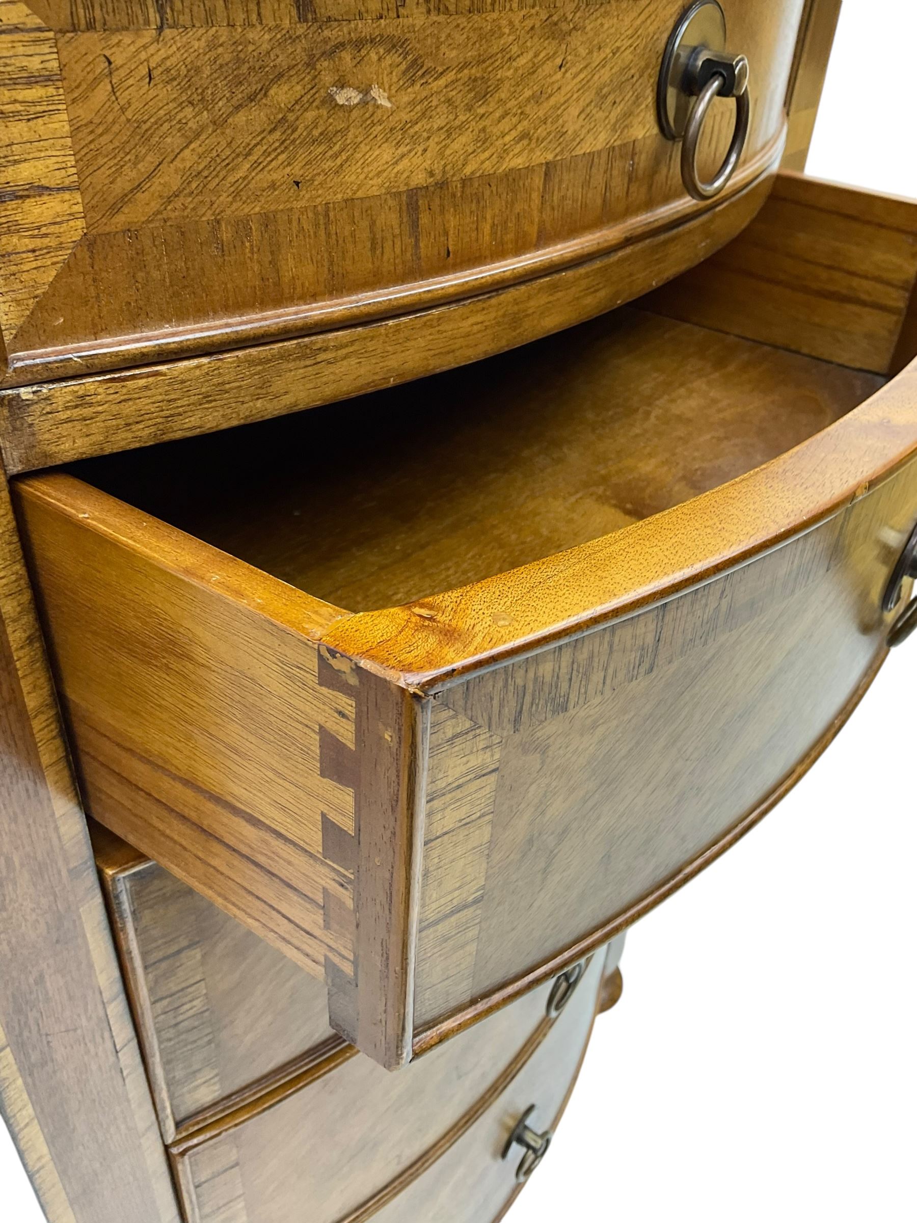 Frank Hudson - mid-20th century Mindi ash and burr walnut bow-fronted lingerie chest, crossbanded hinged top concealing vanity mirror, over five graduated cockbeaded drawers, raised on turned supports