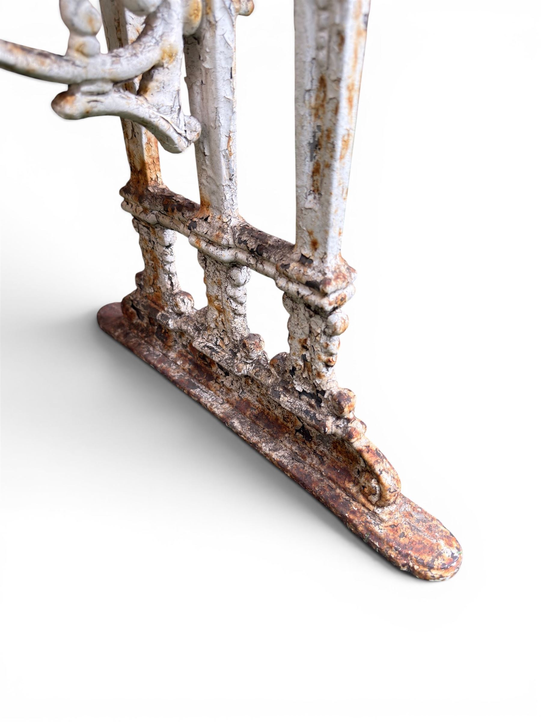 Victorian cast iron garden table, rectangular slate top raised on pierced scrolling foliate end supports with urn and column designs, united by a spindle support stretcher with scrolling acanthus spandrels, stamped 'Registered Design' with indistinct number, in distressed white painted finish
