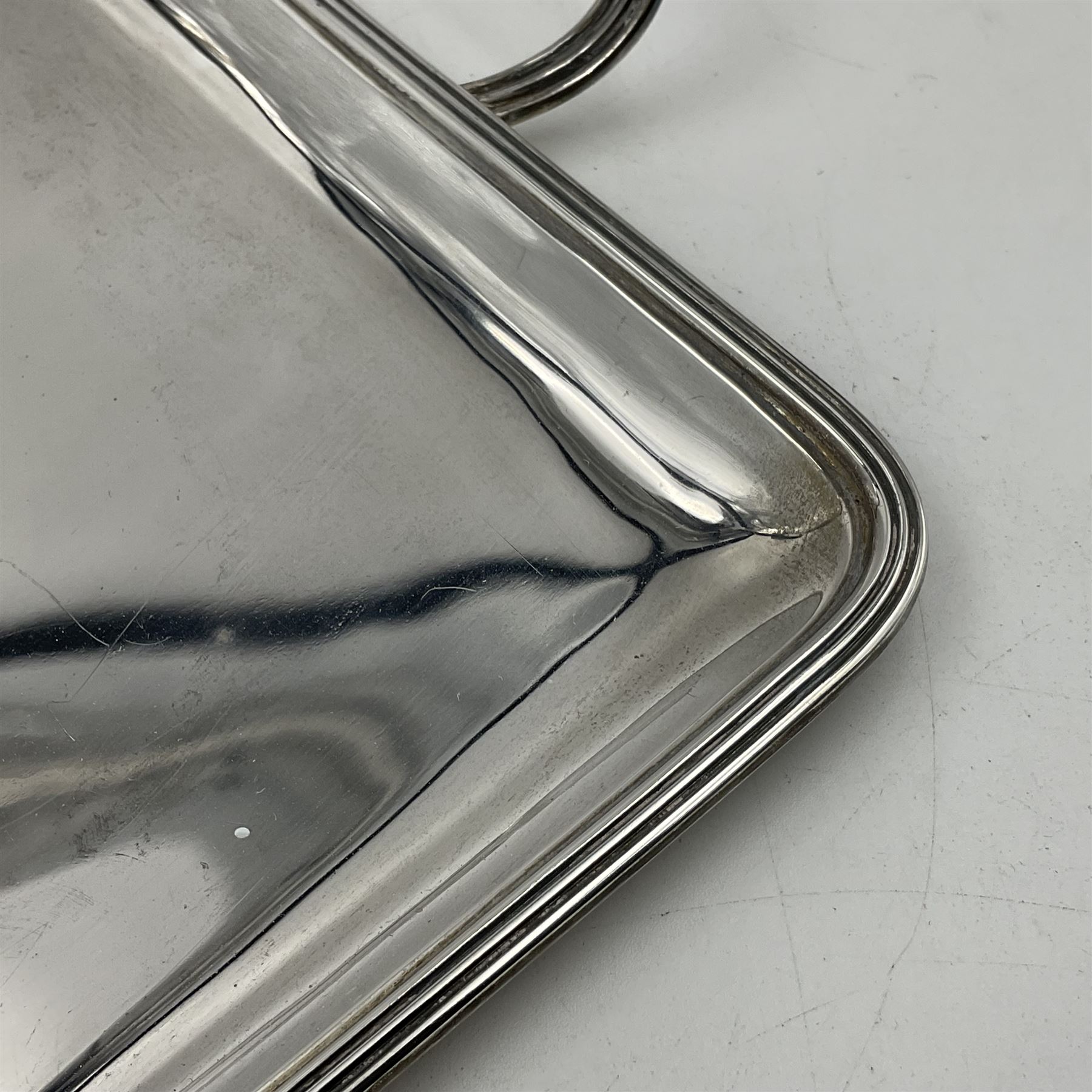 Small early 20th century silver tray, of rectangular form with reeded edge and twin reeded handles, hallmarked Asprey & Co Ltd, London 1914, including handles W26.5cm