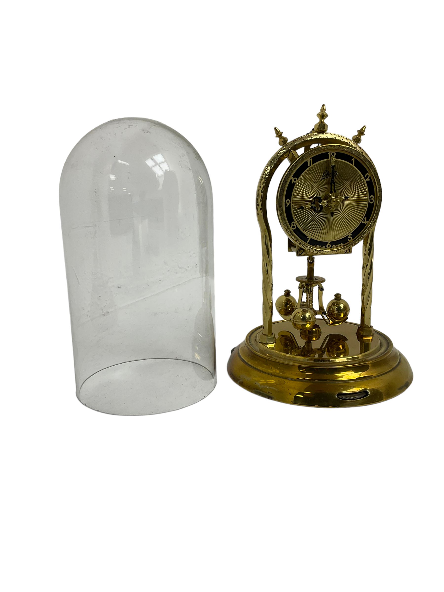 Schatz - mid-20th century German 400 day torsion clock, with a gilt dial and black chapter, Arabic numerals and pierced hands, three ball rotary pendulum and glass dome, original box, packaging and instruction booklet. Torsion suspension spring intact.
