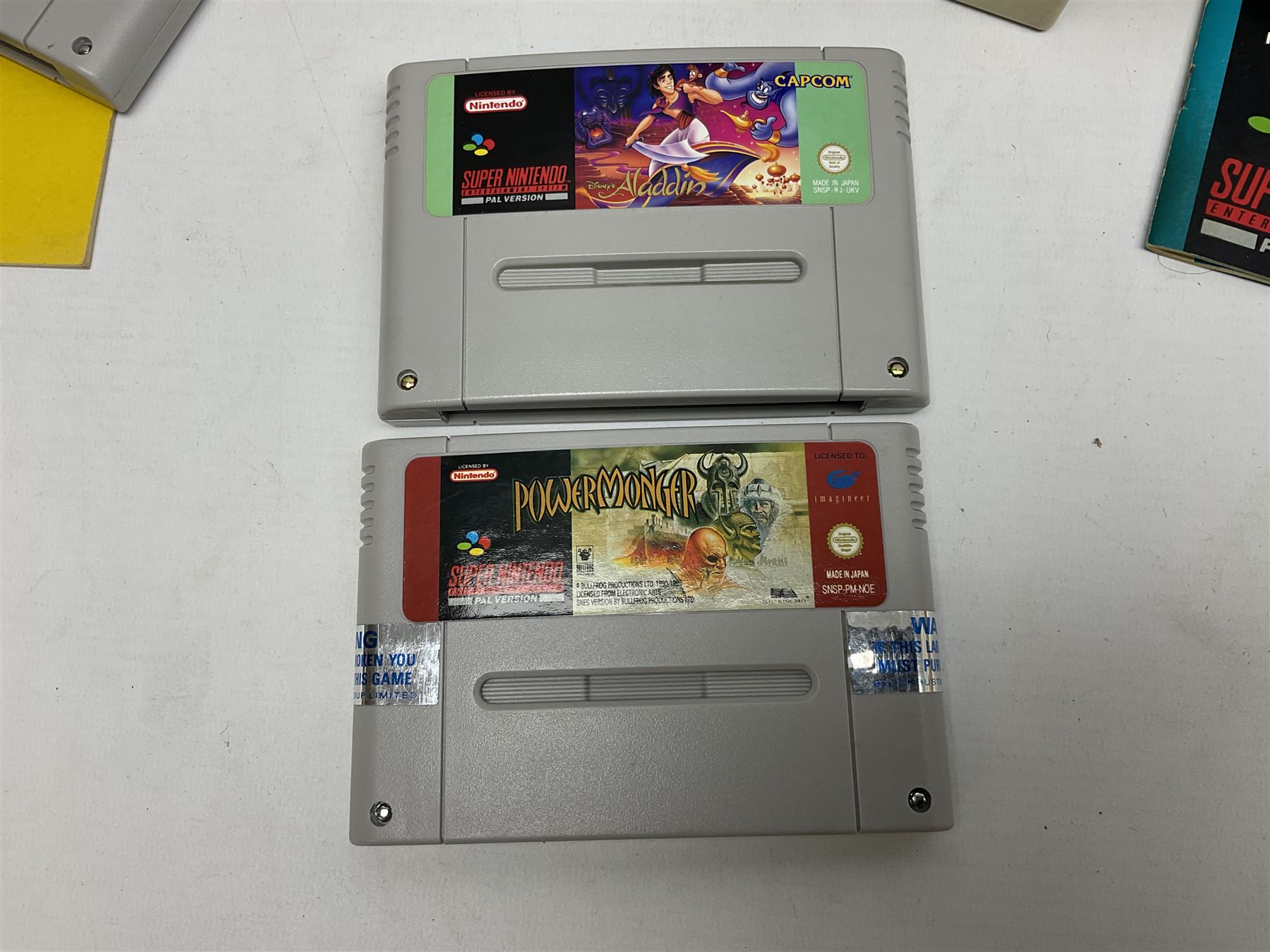 Two Super Nintendo Entertainment System (PAL) controllers, accessories and games. Super NES Game Commander with original box and instruction booklet, Super NES Nintendo Scope (1992) transmitter gun, receiver, Super NES Nintendo Scope 6 game with original instruction booklets. Further games to include ‘The Legend of Zelda a Link to the Past’, ‘Super Mario World’, ‘Super Mario Kart’, ‘The Lawnmower Man’, and ‘Exhaust Heat’, all with original instruction booklets. ‘PowerMonger’ and Disney’s ‘Aladdin’ game cartridges only 