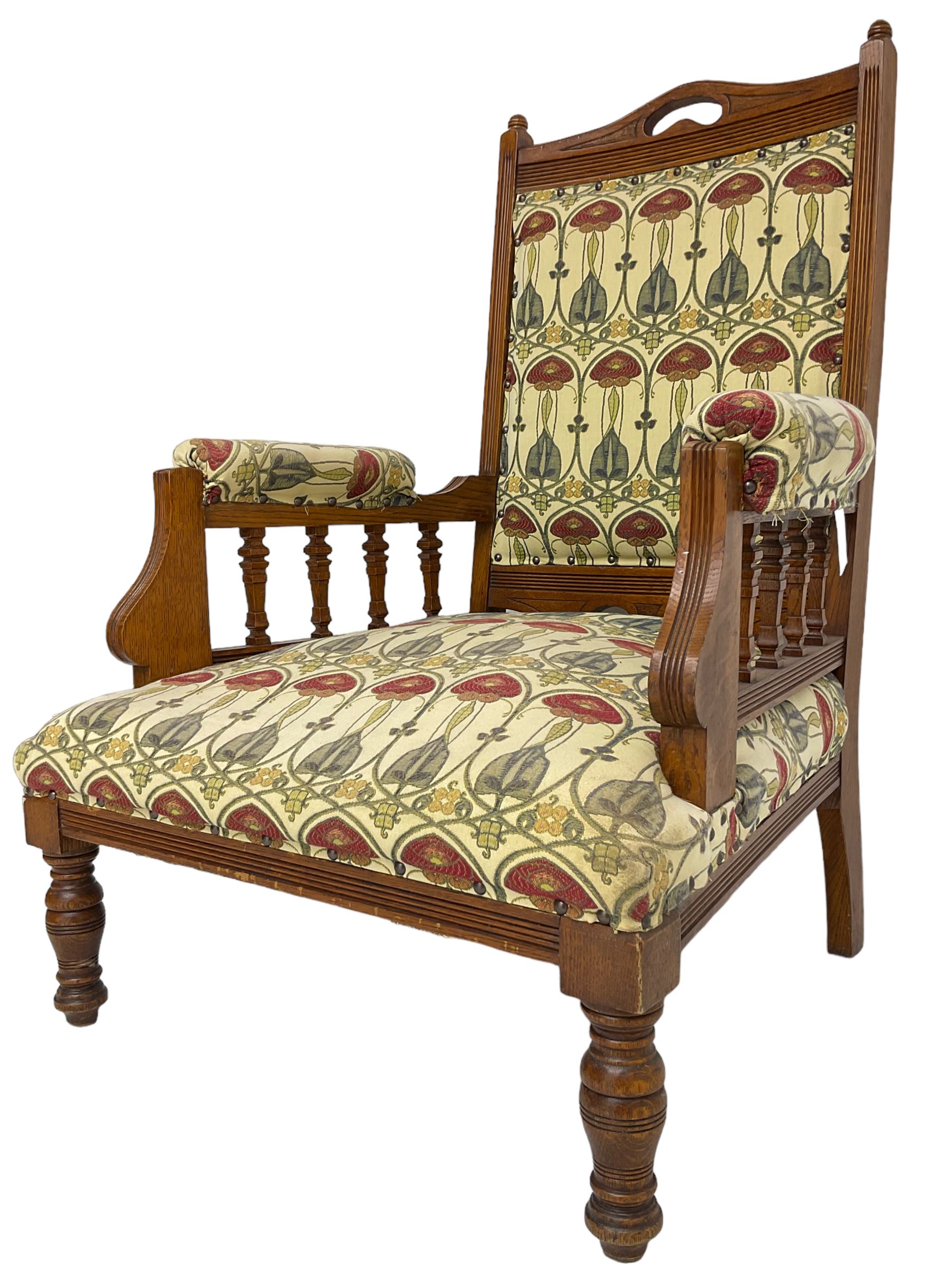 Early 20th century armchair, back and sprung seat upholstered in Art Nouveau patterned fabric, raised on ring turned supports, the frame with all-over reeded decoration