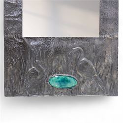 Early 20th-century Arts and Crafts pewter wall mirror, rectangular bevelled mirror plate within a punched pewter frame repoussé decorated with herons among reeds, with a central inset green enamel cabochon panel