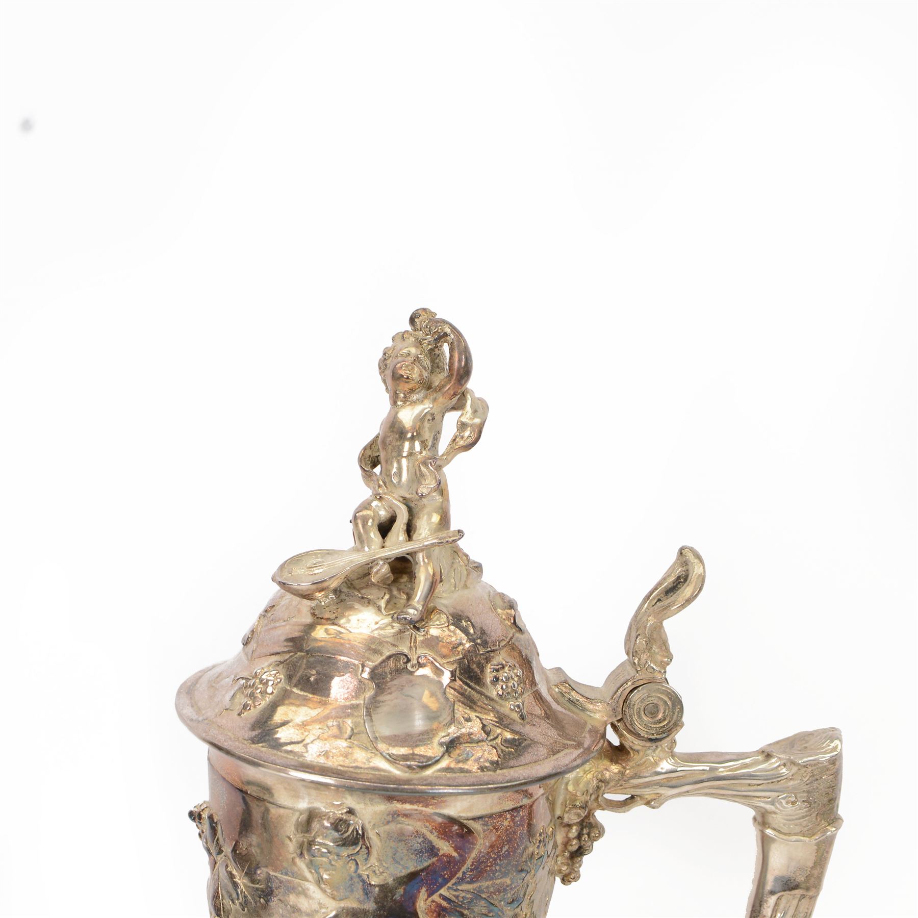Large late 19th/early 20th century WMF Art Nouveau silver plated stein or jug, circa 1900, the bellied body cast and applied with Bacchanalian figures, the domed cover with putti finial, and handle modelled as a vine, the whole upon four fruit and leaf mounted feet, marked beneath for WMF and engraved with initials CHE and dated 1911, H40.5cm
