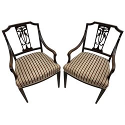 Edwardian mahogany framed three-piece salon suite - two-seat sofa, stepped cresting rail over acanthus and scroll carved pierced splat, upholstered in striped fabric (W124cm, H87cm, D62cm); and a pair of matching armchairs (W60cm) 