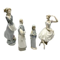 Four Lladro figures, comprising an example modelled as a ballerina dancer seated upon a stool, a further figure modelled as a female stood in wind with a basket of flowers at her feet and book behind her back, and two other examples modelled as young girl with lamb and girl with lilies, tallest H35.4cm