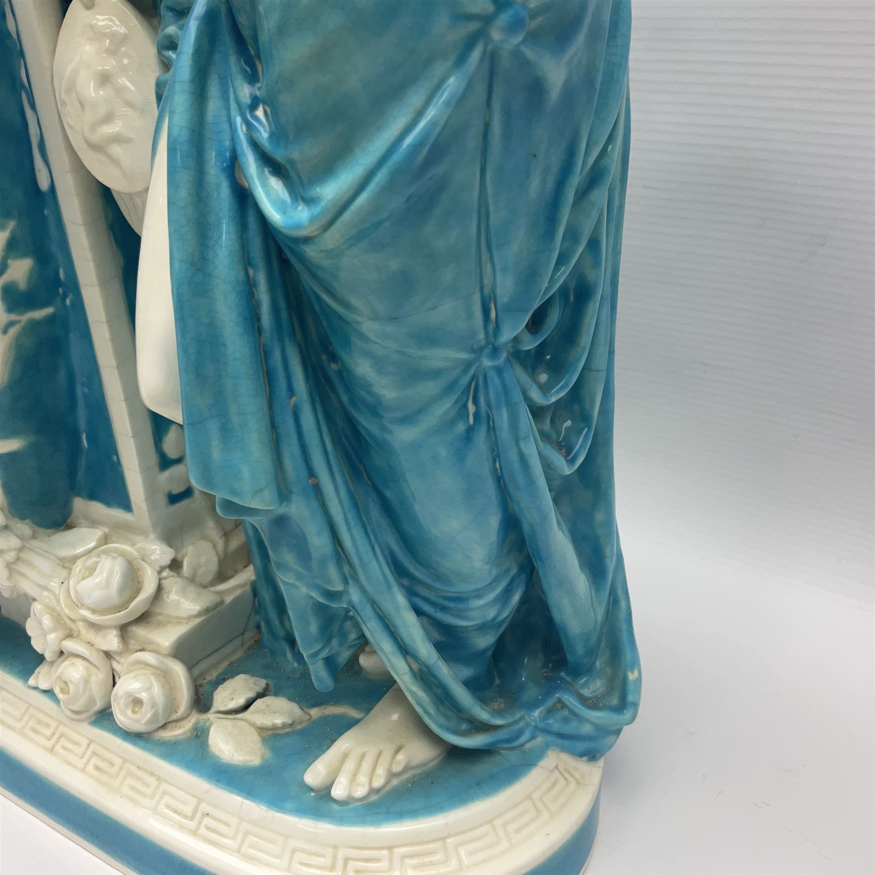 Rare 19th century Minton turquoise glaze majolica 'The Reader' flower holder, after Albert Carrier-Belleuse, modeled as a maiden in classical drapery reading whilst leaning against the pillar back of the helmet shaped cistern detailed with a caryatid and floral swags, the whole upon an oval plinth with Greek key border, with impressed marks beneath, H44cm