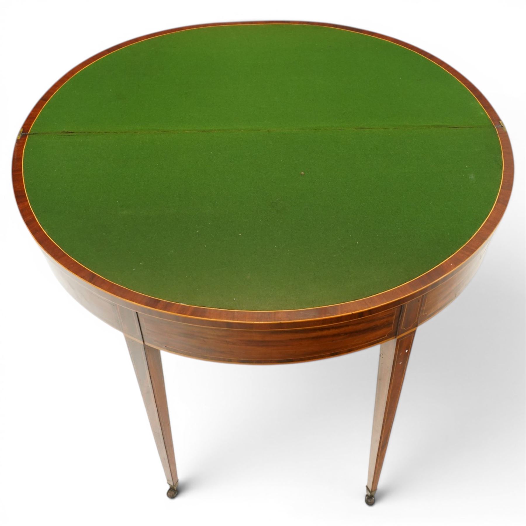 George III inlaid mahogany demi-lune card table, the hinged lunette top inlaid with satinwood stringing and crossbanding, opening to reveal a baize line interior, banded frieze over single gate-leg action and square tapering supports with castors
Provenance: Kirkham Hall