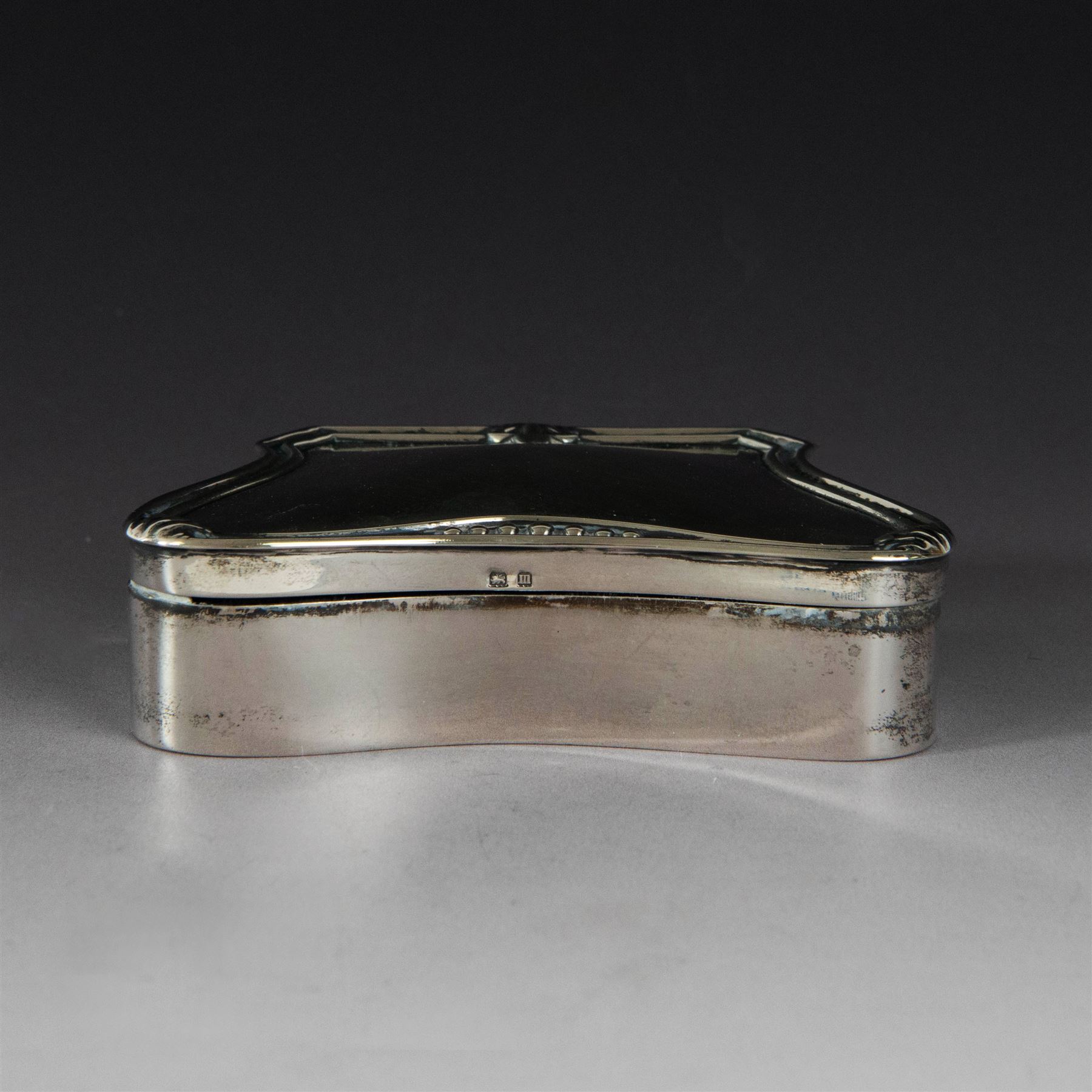 Early 20th century silver mounted jewellery box, with curved front and embossed palmette rim, opening to revel padded interior with weighted base, hallmarked A & J Zimmerman Ltd, Birmingham 1911, H3cm, W11cm
