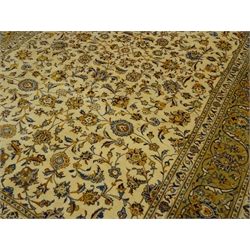  Persian Kashan pale gold ground rug carpet, the field decorated with trailing foliage and stylised flower heads, scroll patterned guarded border, 364cm x 242cm  