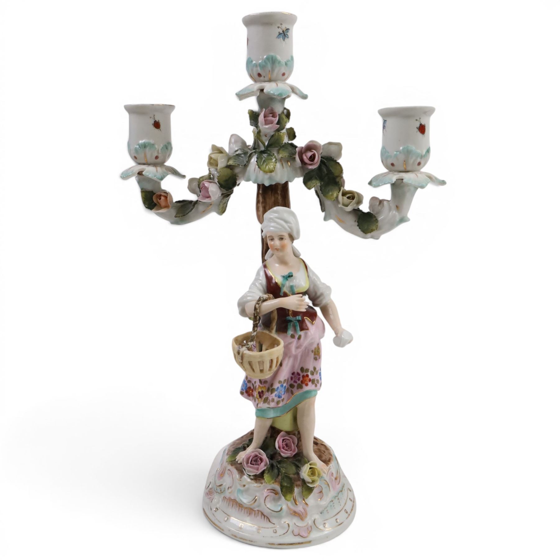 Pair of 19th Century German three-branch figural candlesticks, the figures each in floral dress against a tree, the branches decorated in relief with roses and the sconces painted with insects, H33cm 