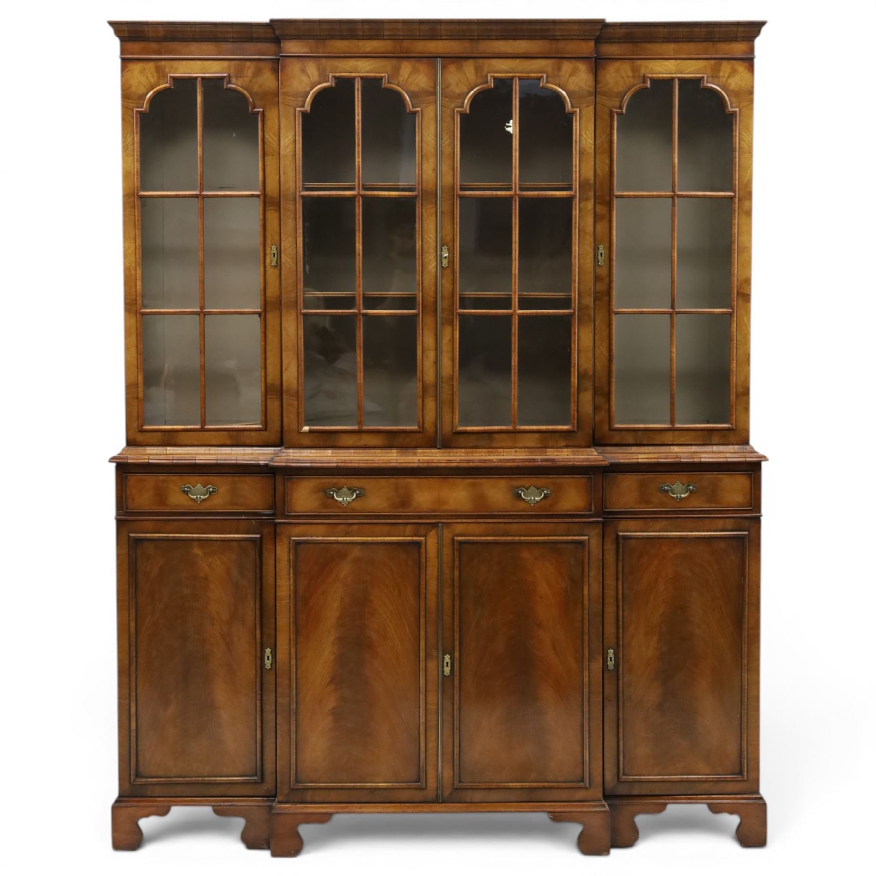 Georgian design mahogany breakfront bookcase on cupboard, projecting cornice over four arched astragal glazed doors, base fitted with three drawers over panelled cupboards, raised on bracket feet