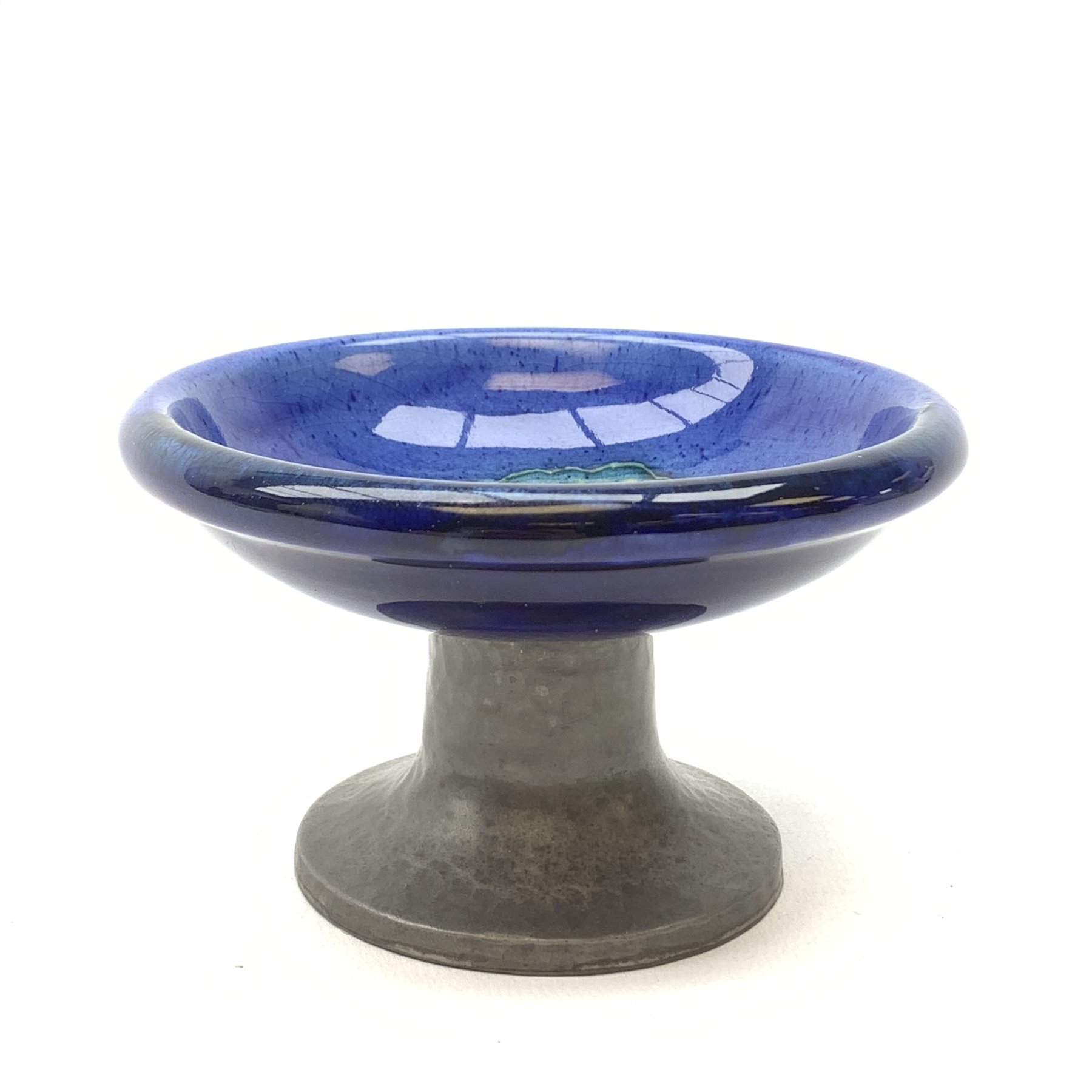 William Moorcroft for Liberty & Co, small pedestal dish, the shallow bowl decorated in the Moonlit Blue pattern, raised upon a Tudric pewter base, impressed beneath Made in England, Tudric Moorcroft 01339, H7cm, D11cm