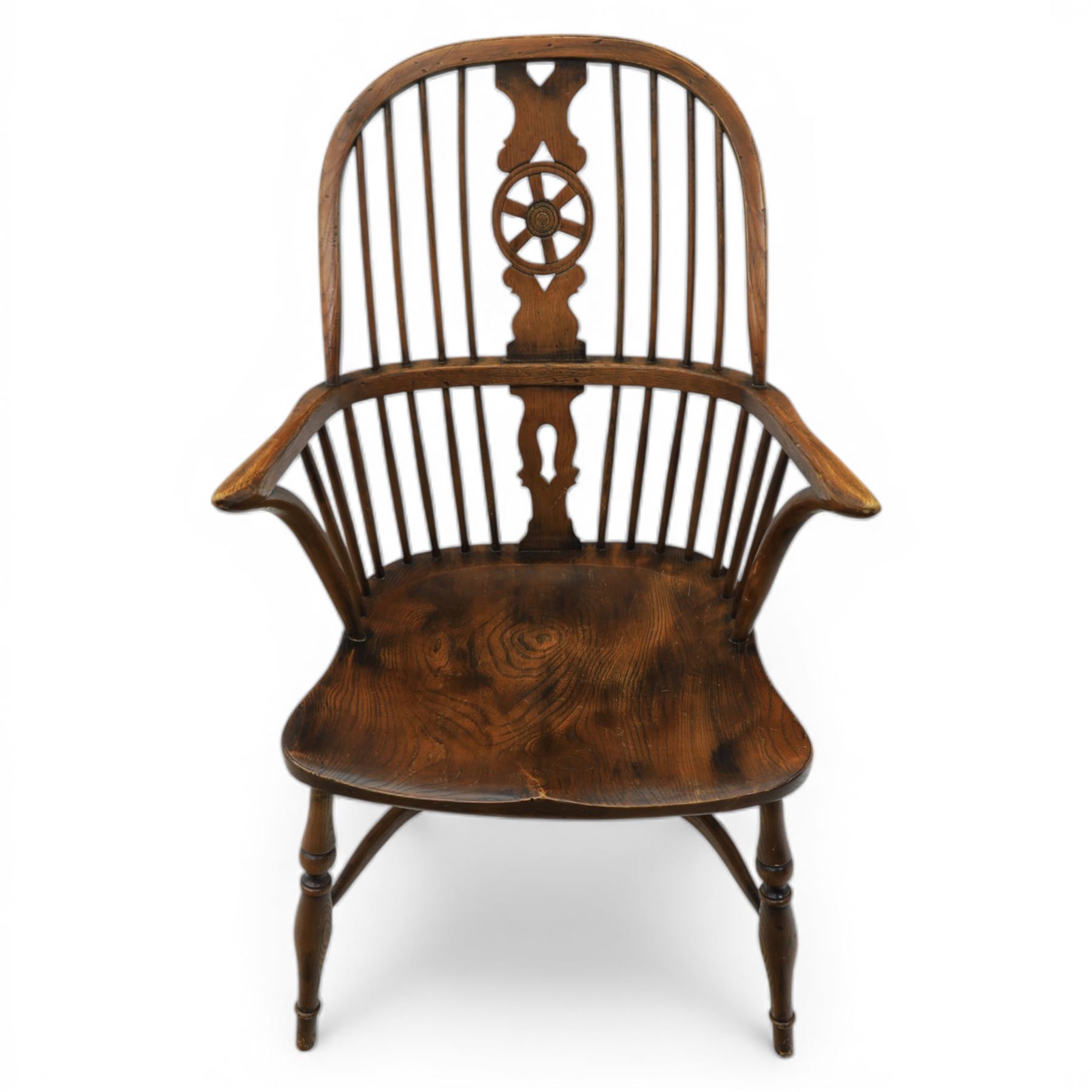 Late 19th century stained elm and beech Windsor armchair, the arched hoop back with pierced wheel splat above shaped lower splat between turned spindles, shaped arm rail on turned supports, saddle seat, raised on turned legs united by a crinoline stretcher