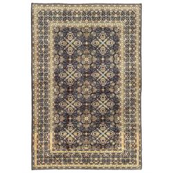 Persian indigo and pale gold ground rug, overall busy geometric design, the field decorated with hooked Hac and palmette medallions surrounded by densely patterned zig-zags and stylised foliate motifs, the border decorated with smaller Hac motifs, within multiple guard stripes 
