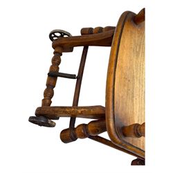 Late 19th century American oak child's metamorphic high chair and play table, carved spindle backrest with pierced splat, detachable tray with abacus and hand painted pastoral decoration, on turned supports with metal wheels