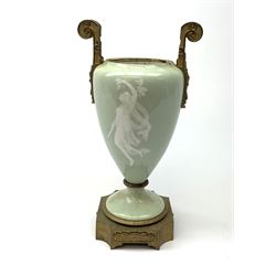 A pate sur pate celadon green vase, of baluster form decorated with a classical female figure to one side, and floral swag with ribbon and musical trophy to the other, with twin gilded scroll handles, and raised upon a gilded base, overall H38.5cm. 