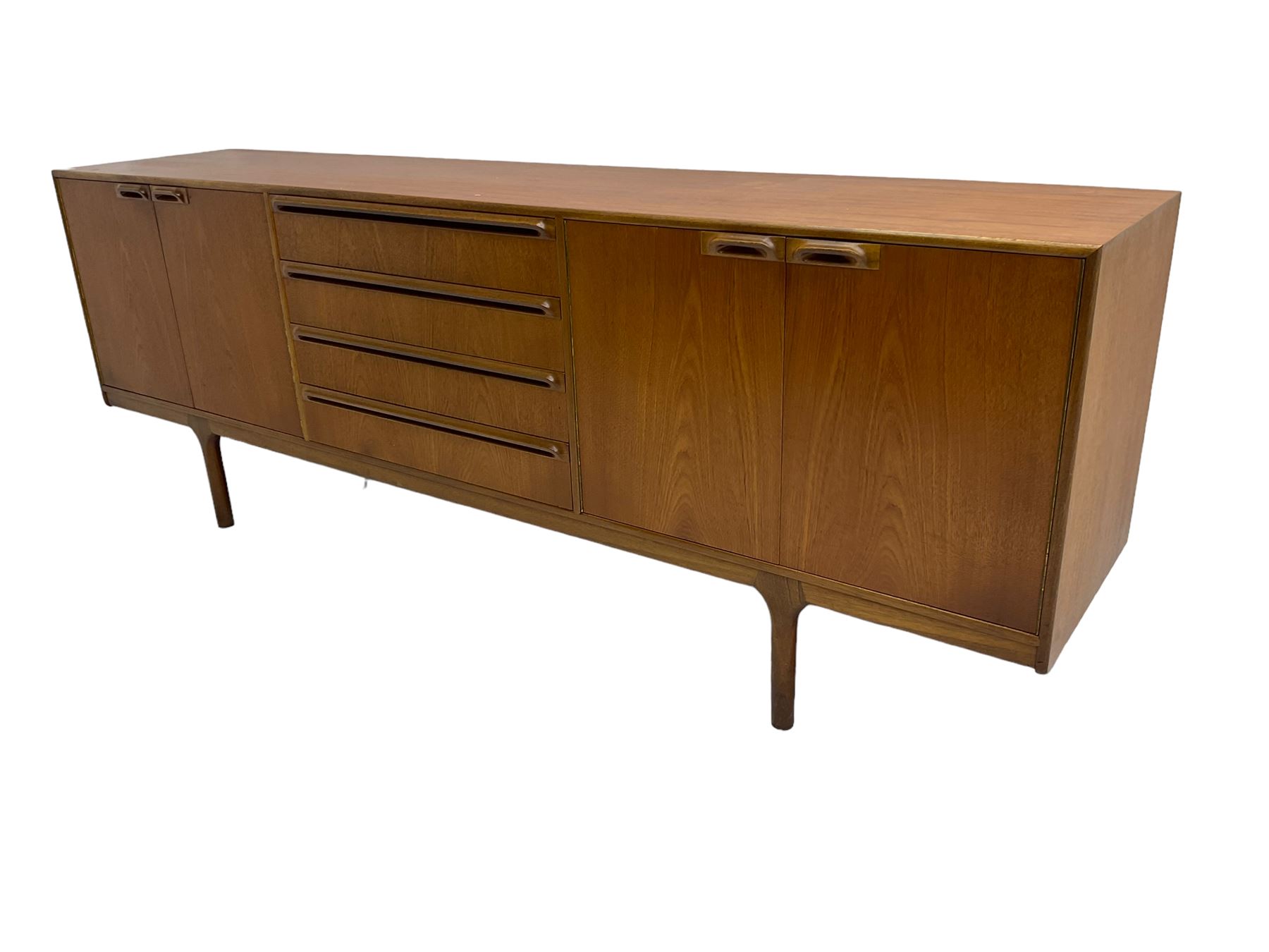 Tom Robertson for AH McIntosh & Co of Kirkaldy - mid-20th century teak sideboard, fitted with four central drawers, flanked by cupboard enclosing shelves and sliding tray, raised on cylindrical supports
