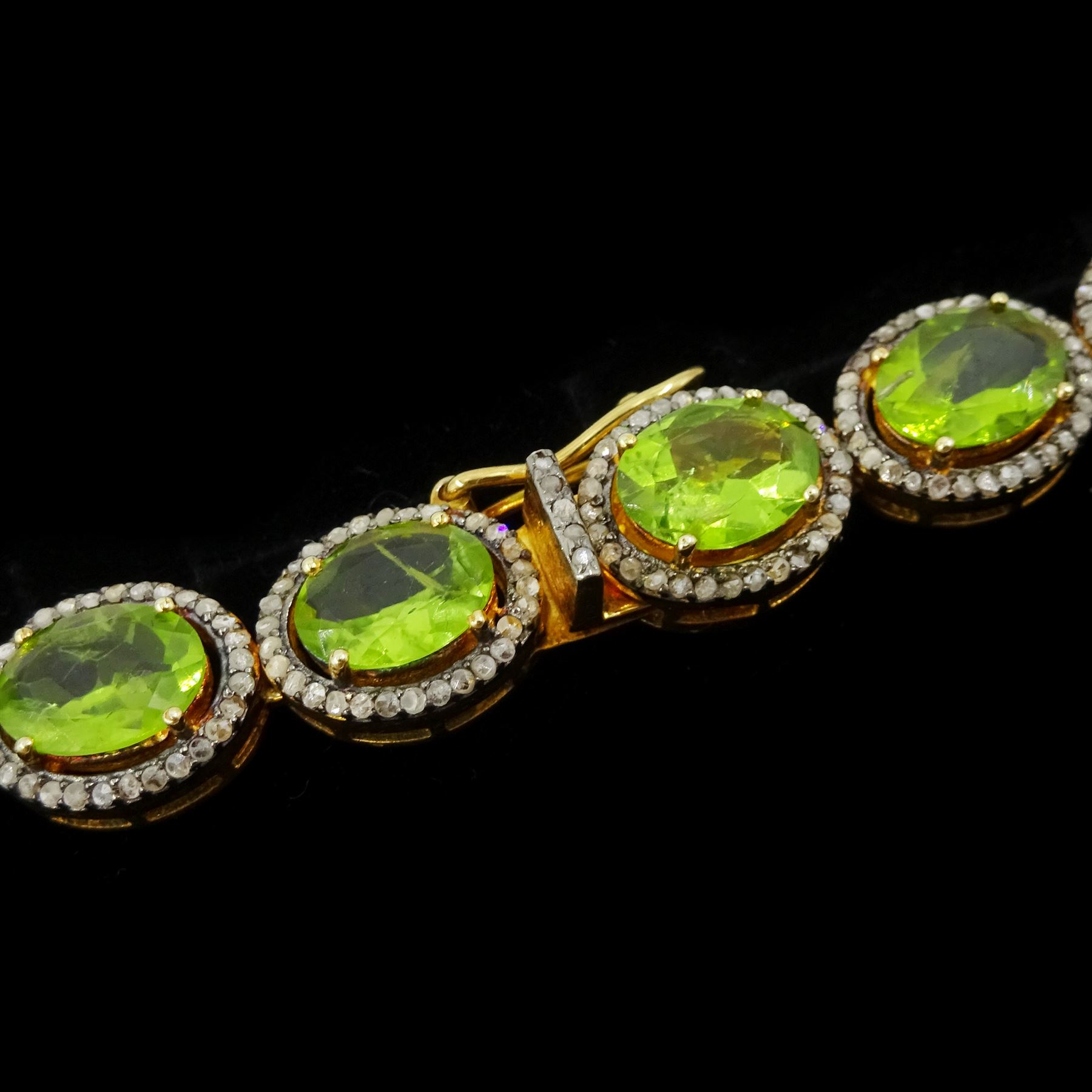 Silver-gilt peridot and diamond necklace, thirty-eight clusters, each set with a single oval cut peridot and round brilliant cut diamond surround, total peridot weight approx 57.00 carat, total diamond weight approx 5.00 carat