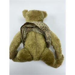 Early 20th century German Steiff teddy bear c1910 with wood wool filled humped back mohair body, swivel jointed head with black boot button eyes and horizontally stitched black nose and mouth, FF metal button to left ear, jointed elongated limbs with felt paw pads and black stitched claws H13