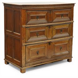 18th century oak chest of drawers, rectangular plank top with chip carved frieze, fitted with three long geometrically panelled drawers with applied mouldings, later brass drop handles, on stile supports, panelled sides and boarded back