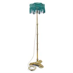 Art Deco brass standard lamp, telescopic column with level action, ring turned collars, raised on a shaped tri-form base with fluted pad feet, complete with green fabric fringed shade