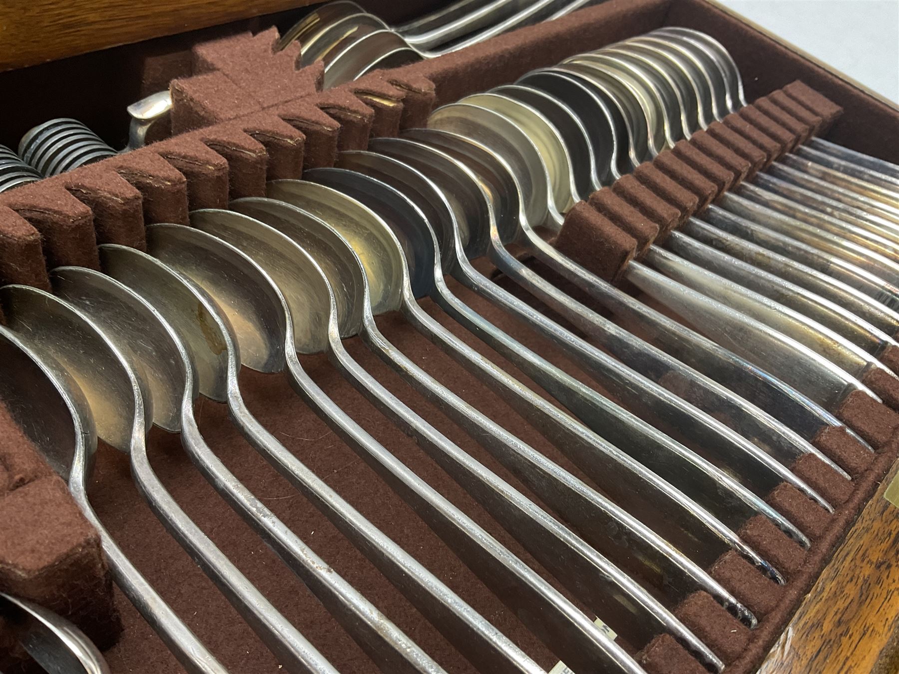 Elkington & Co part canteen of silver plated and stainless steel cutlery, to include simulated ivory handled examples, housed in oak and mahogany case, lock plate stamped 'Acme, British Made', W49cm D31cm H18cm