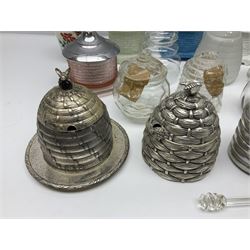 Collection of glass beehive honey pots, to include a blue slag example, milk glass, pink, green, etc together with four white metal examples (16) 