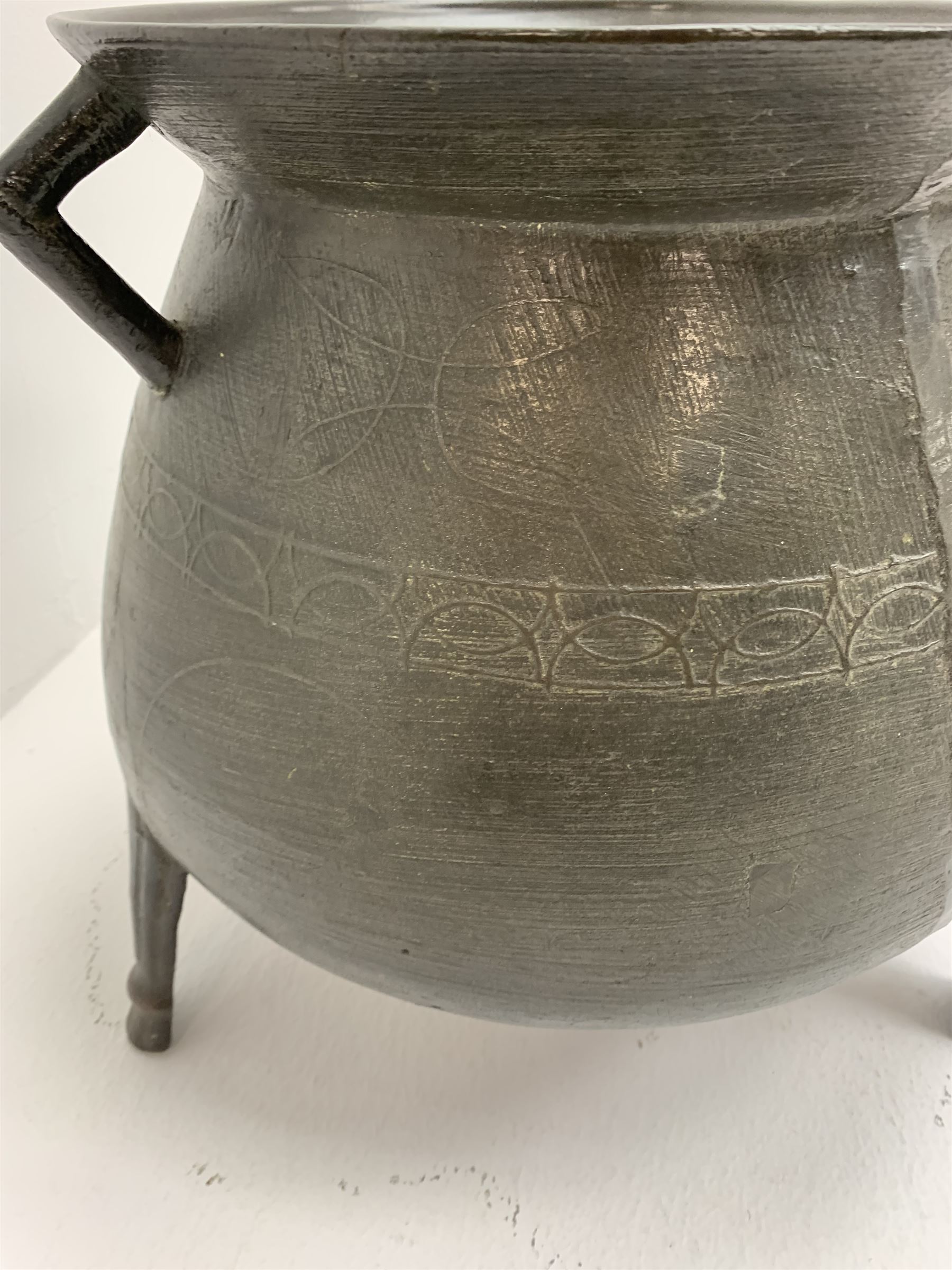 Late 17th/early 18th century bronze cauldron, of bellied form with flared rim and twin angular handles, upon three ribbed outswept feet, detailed with a decorative band beneath four arc founder's mark for John Sturton (I or II) of South Petherton, Somerset and a capital 'I', H40cm, rim D36cm