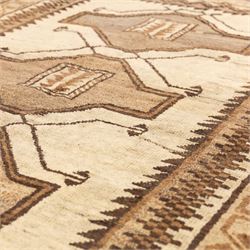 North West Persian Gabeh hand-knotted rug, natural ivory field with a vertical sequence of three large stepped geometric medallions in soft shades of brown and taupe, each enclosing stylized tribal motifs, flanked by narrow guard borders incorporating chevron and zigzag designs, with fringe ends 