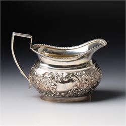 Late Victorian four piece silver tea set comprising teapot, coffee pot, sugar bowl and milk jug with embossed decoration, the cartouches engraved with an initial, the teapot and coffee pot Chester 1899 Maker George Nathan & Ridley Hayes, the sugar bowl and milk jug Birmingham 1899 Maker Thomas Hayes