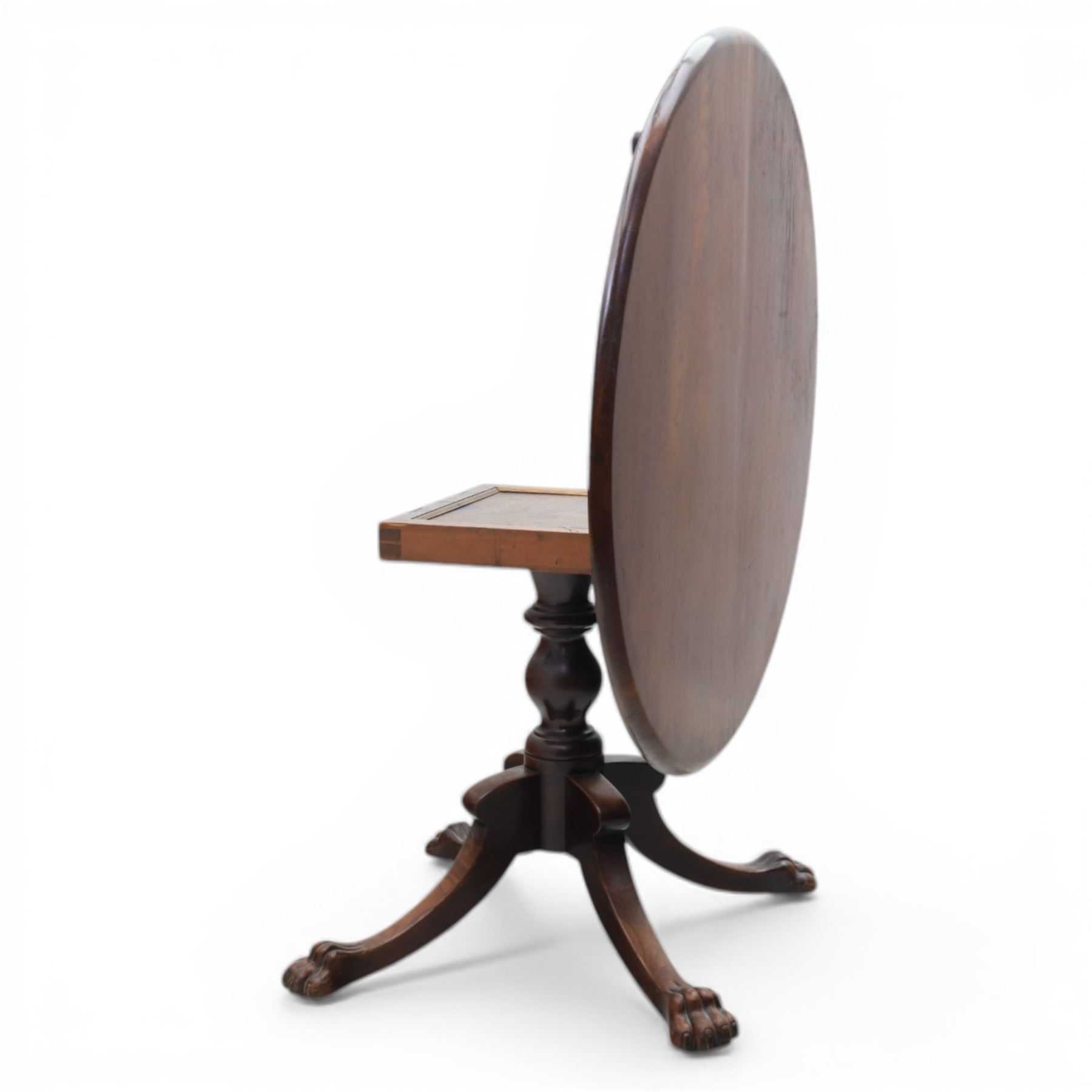 Victorian mahogany dining suite, oval tilt top dining table raised on a quatriform base with paw feet, together with a set of six balloon back dining chairs with green upholstery with cabriole legs 