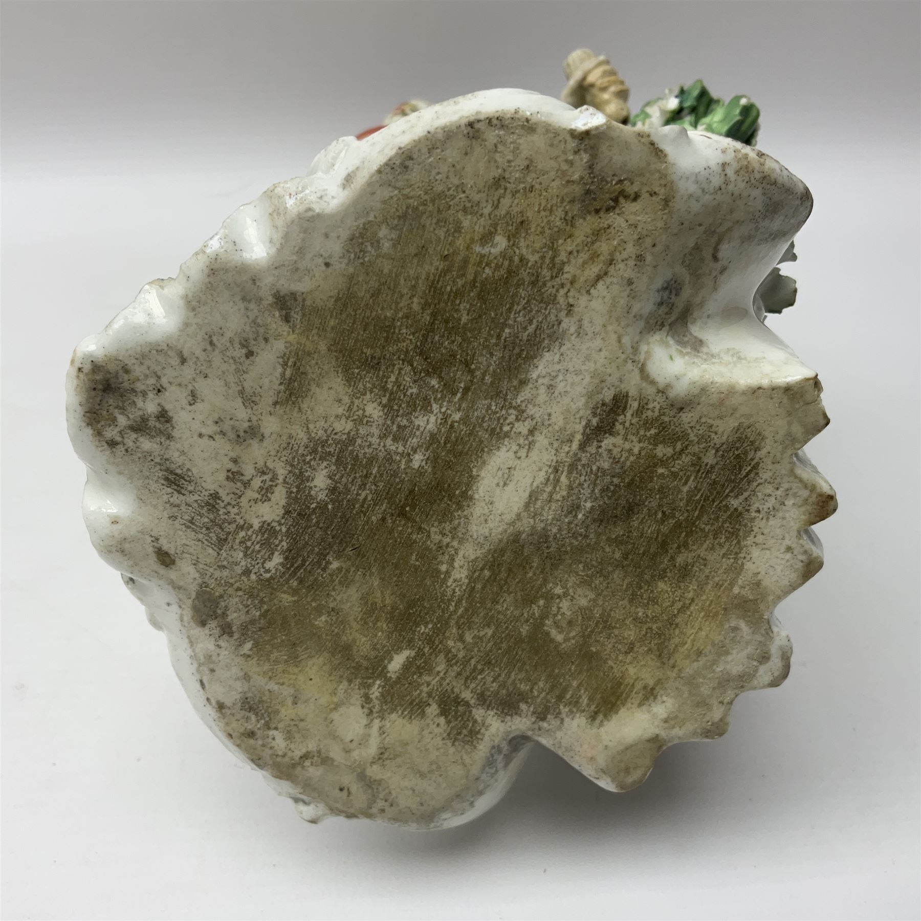 18th century Derby figure of Diana the huntress, circa 1760, modelled reaching for an arrow from quiver across her back, with recumbent hound at her feet, upon a scrolled base with bocage detail, H27.5cm