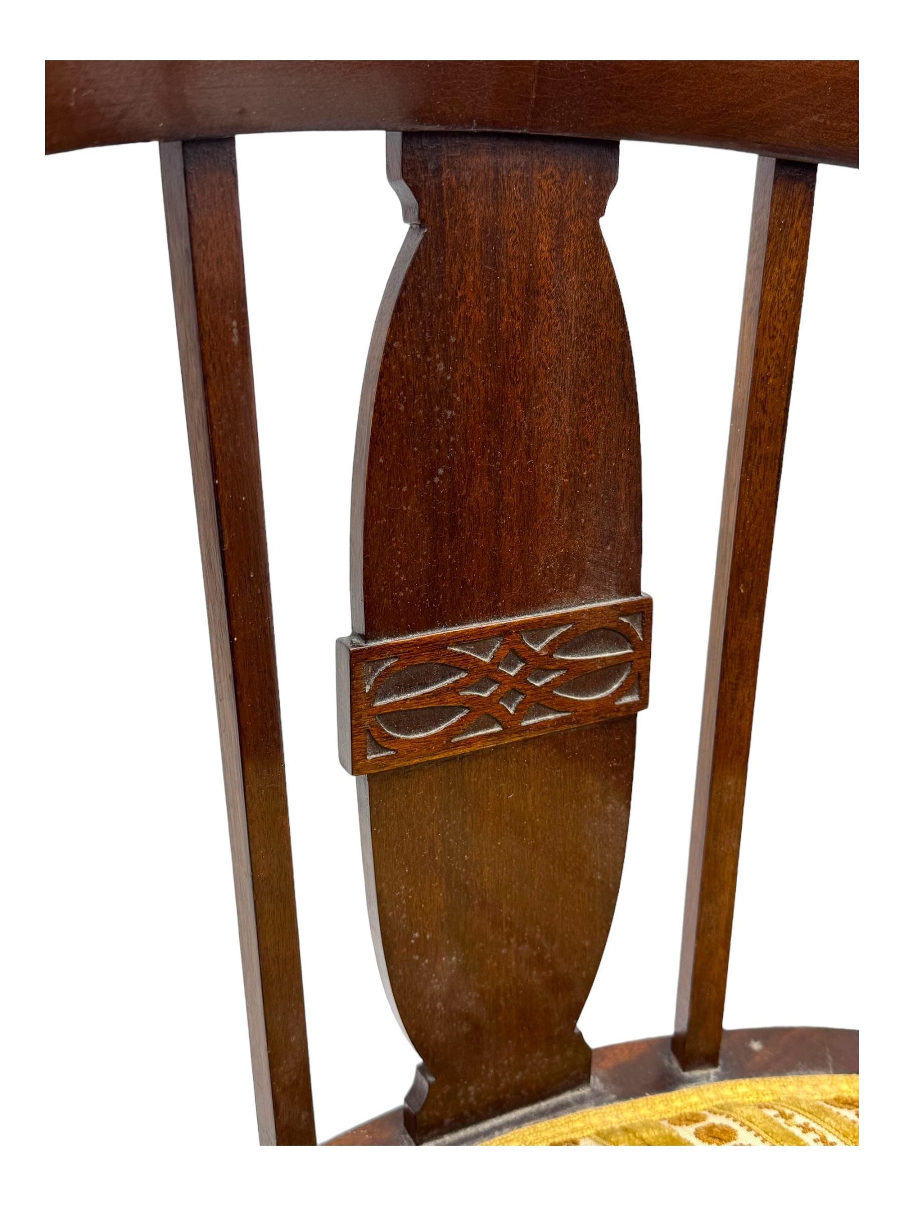 Late Victorian mahogany framed tub chair, rounded backrest with vertical splats and three carved oval medallions, upholstered seat in yellow patterned fabric, on cabriole supports