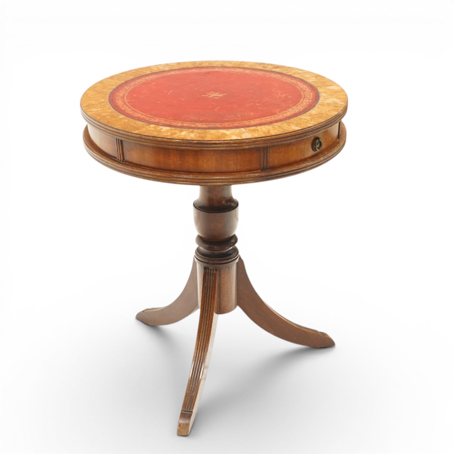 Regency style mahogany drum table, circular red leather inset top with gilt and blind tooling, bird's-eye maple crossbanded border, fitted with two opposing pull-out slides, on turned pedestal and three outswept support