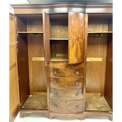 Edwardian inlaid mahogany triple wardrobe, bow front centre with two cupboards above four graduating drawers flanked by two bevel edged mirror doors, shaped platform base 