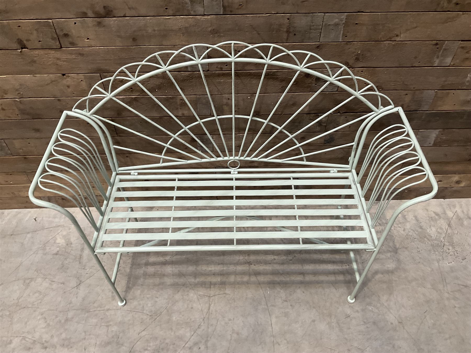 Wrought metal two seat garden bench, sunburst back, painted in pale green finish