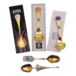 Two Danish silver-gilt year spoons by Georg Jensen, the first example decorated with enamel blue cornflower motif, dated 1972, in original pouch, the second example decorated with enamel pink briar rose motif, dated 1976, in original box, each impressed on underside RA AB, Sterling Denmark, and marked for Georg Jensen, together with two further examples by A.Michelson, the first with orange enamel fan design, dated 1965, impressed on underside A.Michelsen Sterling Danmark, TH, the second with enamel family scene, dated 1973, impressed on underside 925 S A.Michelsen Sterling Danmark, B Spang Olsen, approximate gross weight 6.11ozt (190.4 grams)