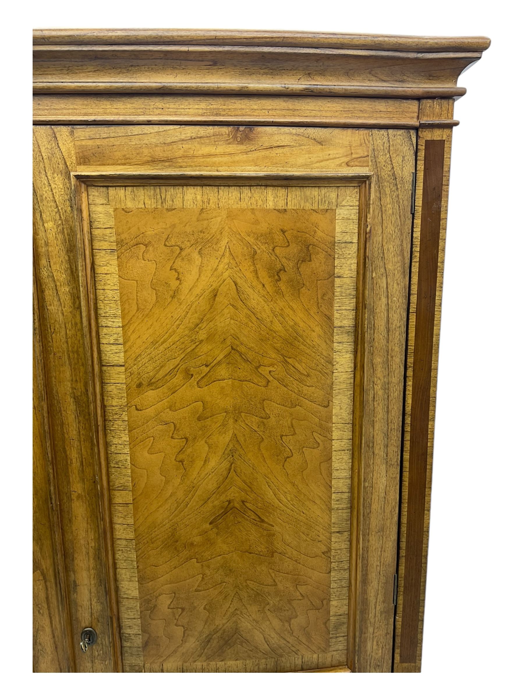 Frank Hudson - mid-20th century Mindi ash and burr walnut double wardrobe, moulded rectangular cornice over two panelled doors with chevron pattern veneers, raised on turned supports