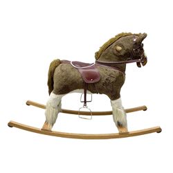 Modern plush covered rocking horse with inset eyes, simulated leather bridle and saddle with metal stirrups, on curving wooden rockers L94cm H64cm