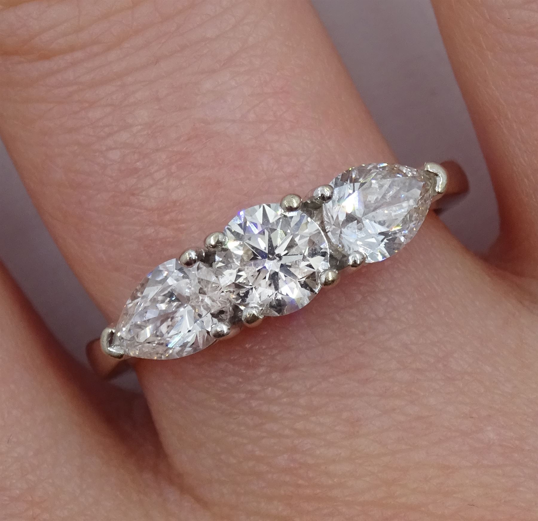18ct white gold three stone diamond ring, central round brilliant cut diamond with two pear shaped diamonds either side, hallmarked, total diamond weight 1.48 carat