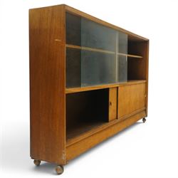 Herbert E Gibbs - Mid 20th century teak bookcase with sliding glazed doors, glazed upper section with adjustable shelf, above to two teak doors, raised on castors