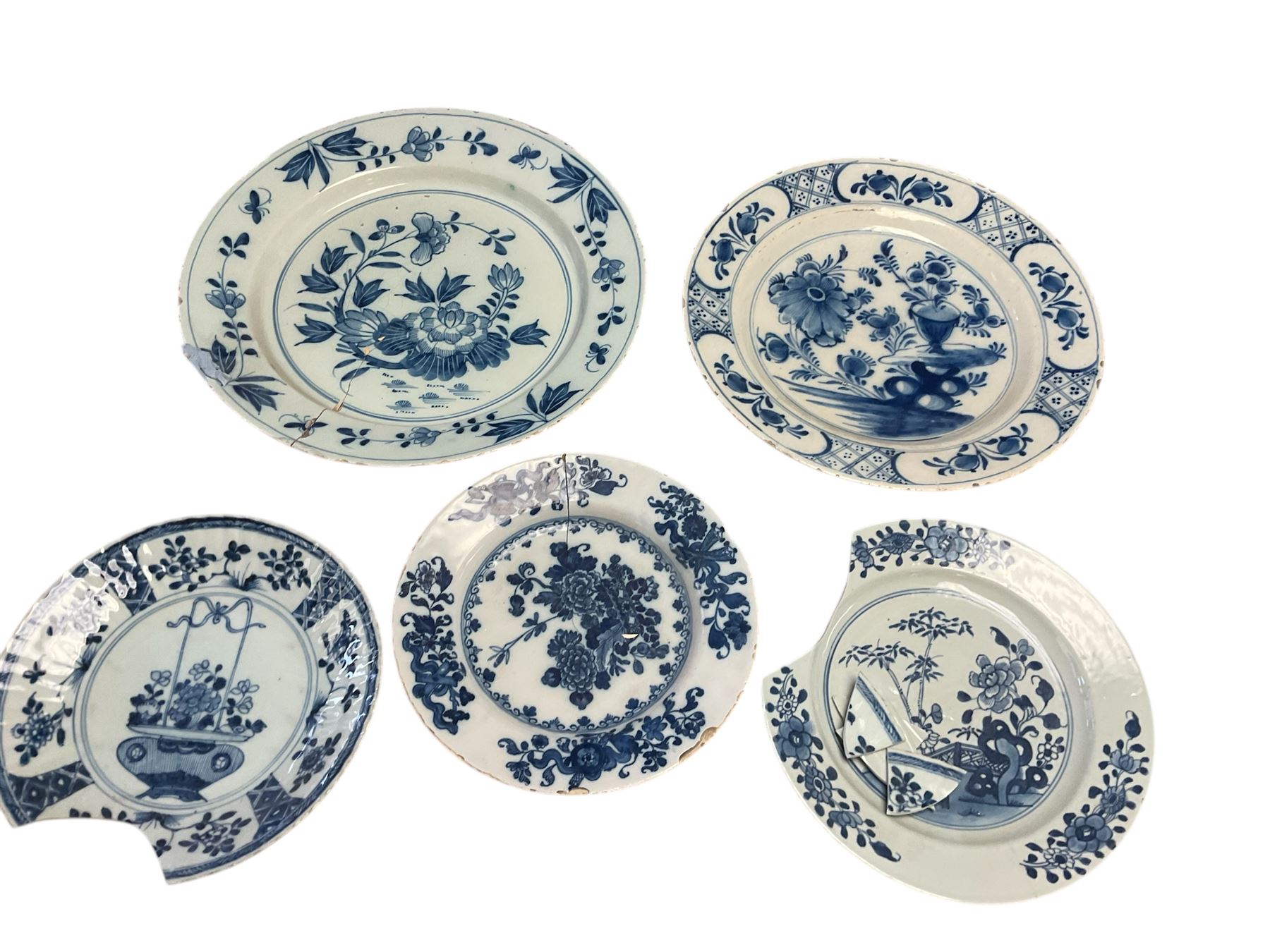 18th century Dutch Delft blue and white plate, of circular form, decorated with a vase of flowers and further blossoming flowers, D30.5cm, together with two 18th century blue and white Delft plates, and two late 18th/early19th century blue and white Chinese export plates, (for restoration), largest example D34cm