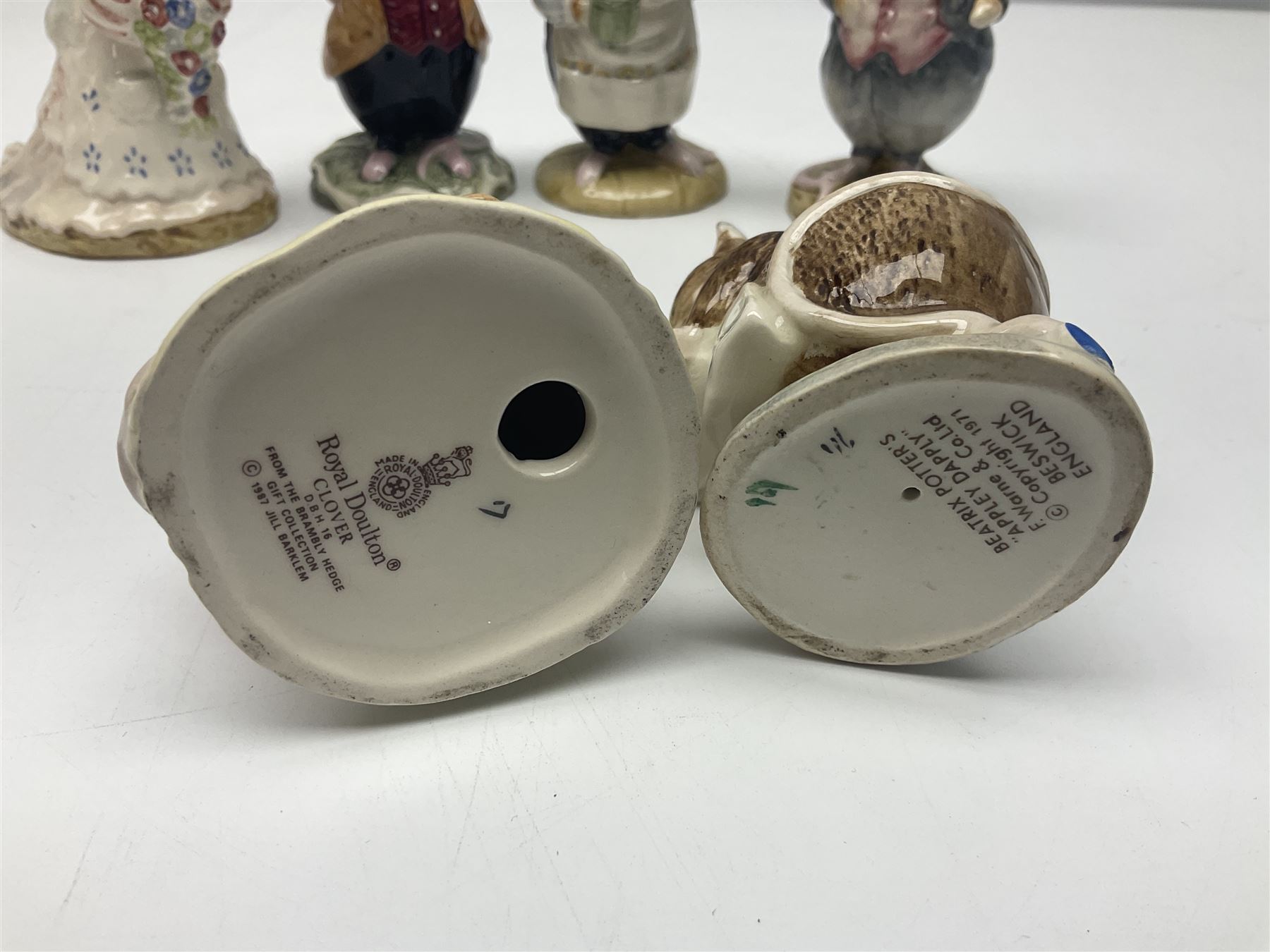 Five Royal Doulton Beatrix Potter figures, comprising Poppy Eyebright, Clover, Lord Woodmouse, Mr Apple and Dusty Dogwood, together with Beswick Appley Dapply figure and three Crummles Beatrix Potter enamel pill boxes