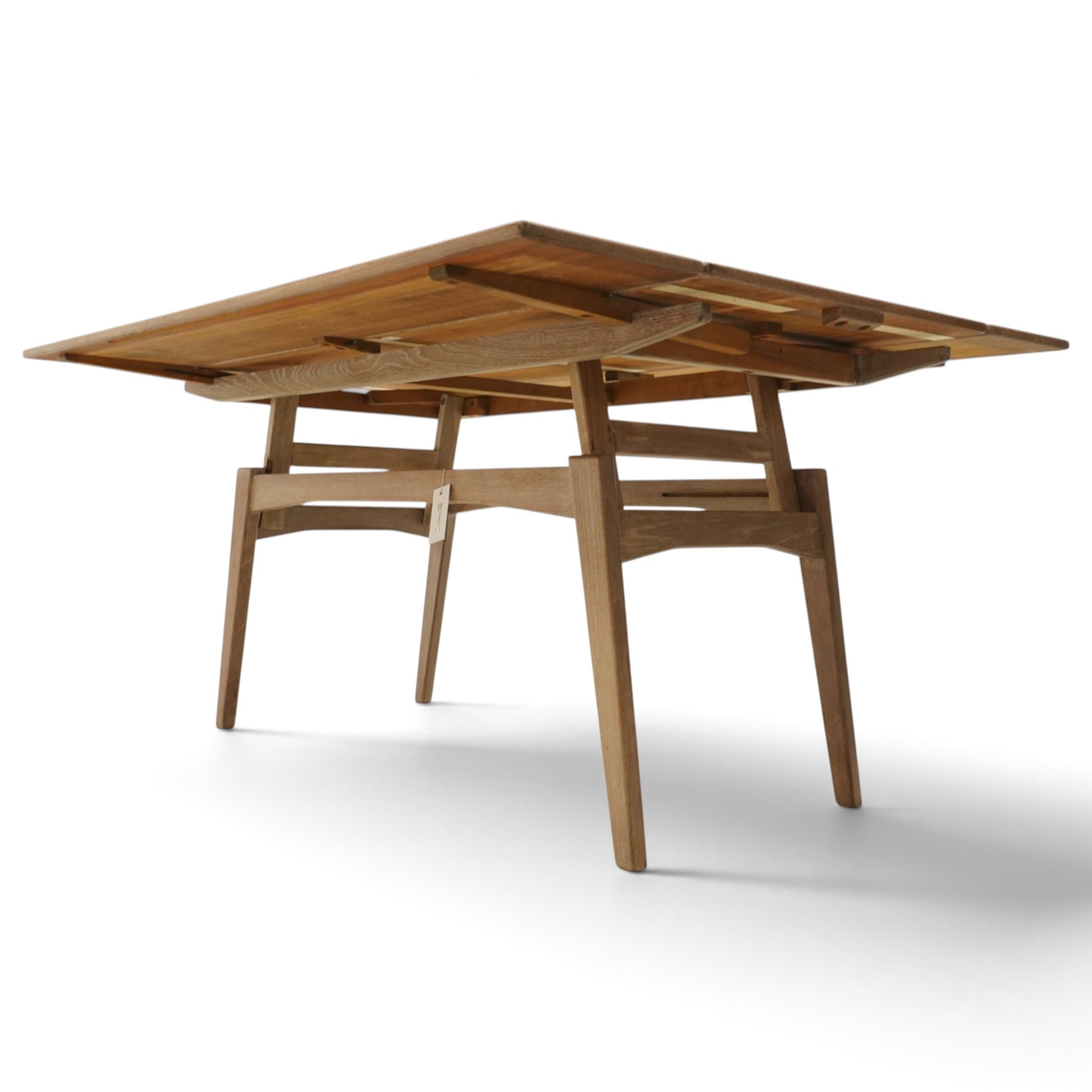 20th century Scandinavian limed oak metamorphic dining-to-coffee table, the rectangular extending top with draw-leaf sides, over an adjustable-height action base, on splayed supports united by stretchers